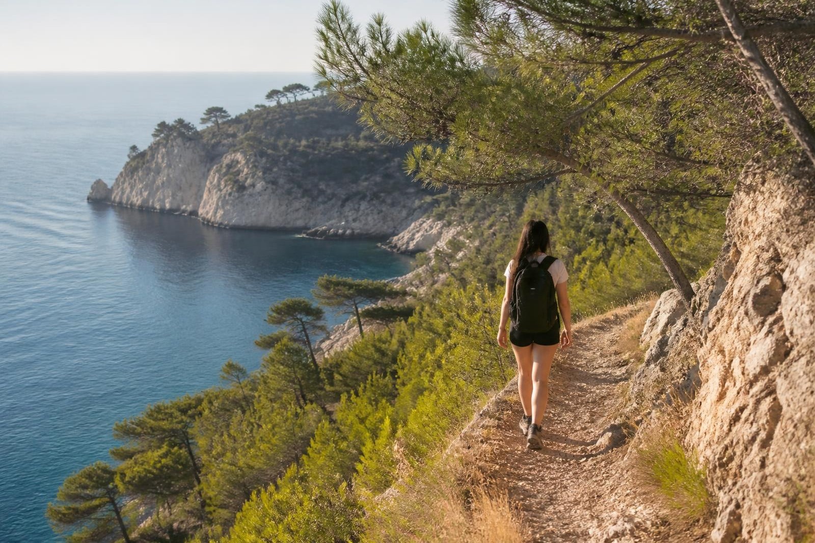 A solo walker on a coastal path above the Mediterranean in Provence