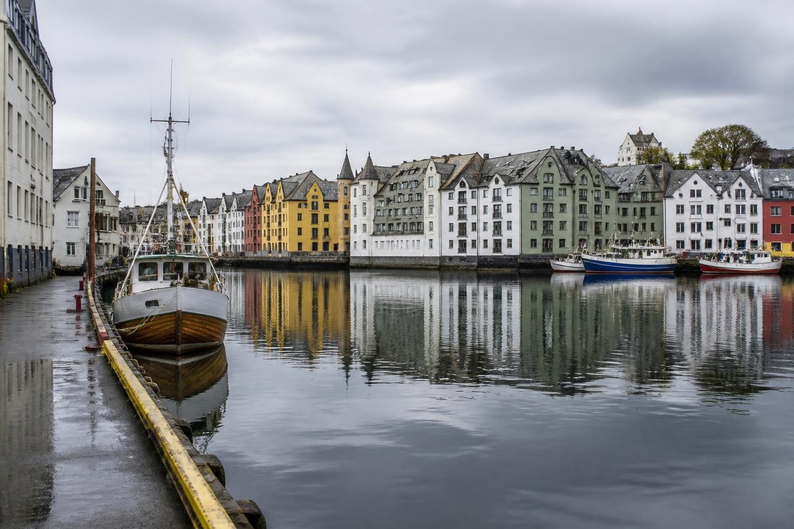 Art nouveau harbour buildings reflected in the calm water at Ålesund